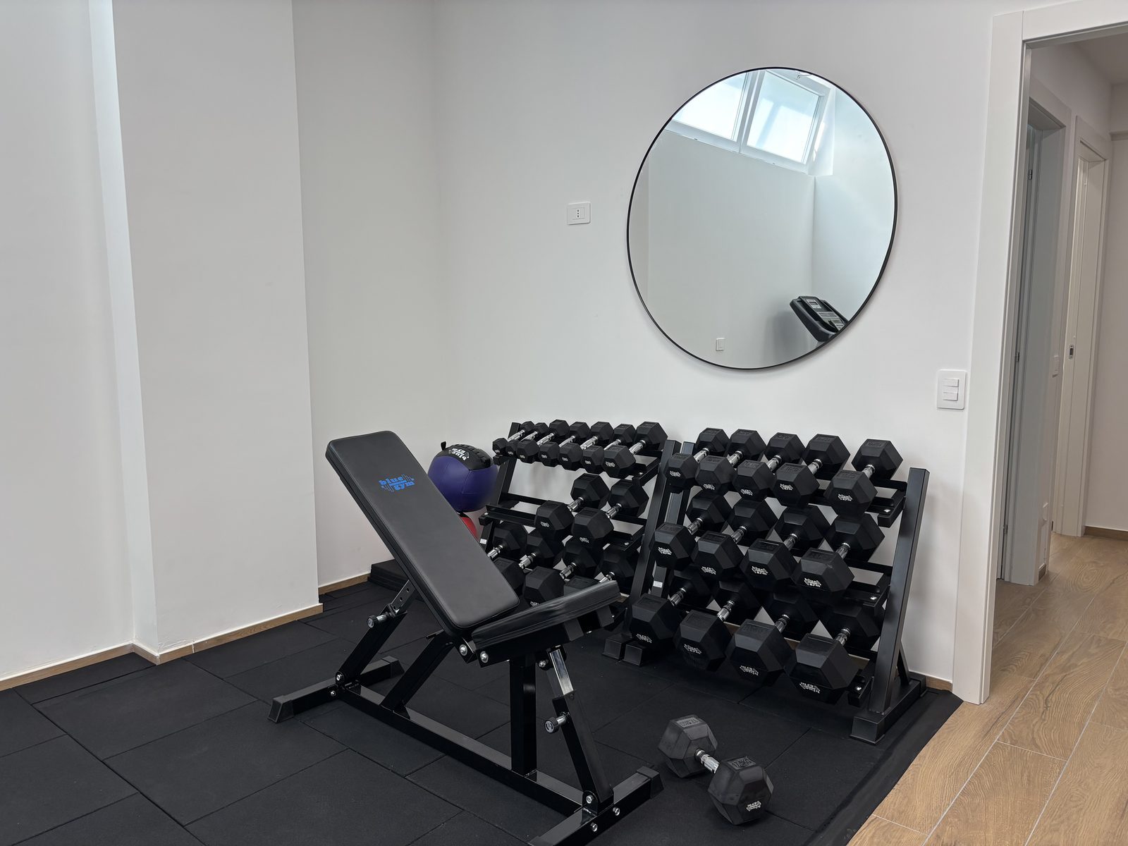 Sala allenamento privata con panca e rastrelliere di manubri
